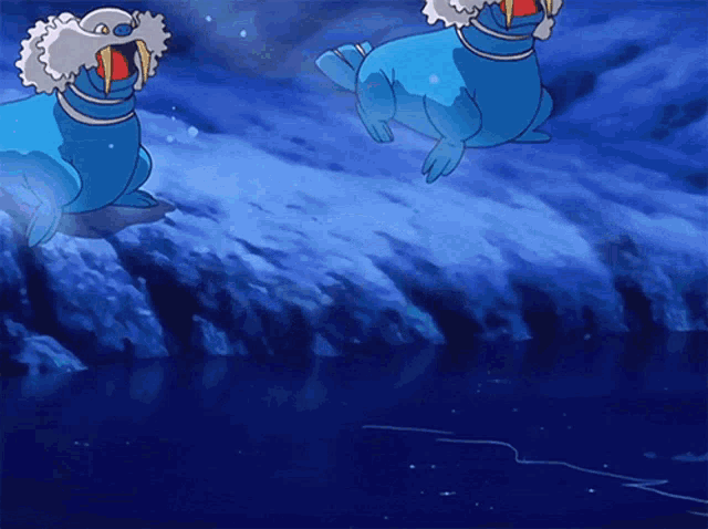 two blue seals are swimming in the ocean