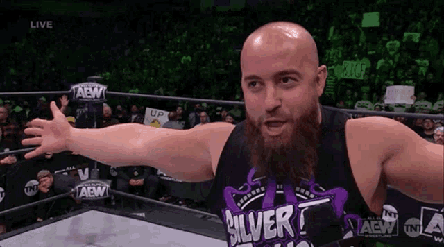 a man with a beard wearing a silver shirt