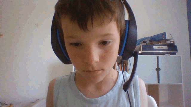a young boy wearing blue headphones with a microphone