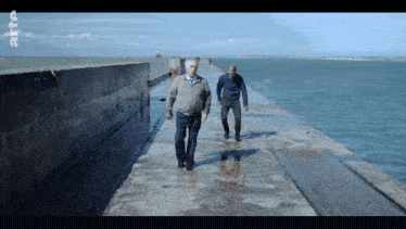 two men walking on a dock with the letters rtc on the bottom right