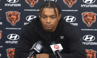 a man sitting in front of a hyundai bears logo