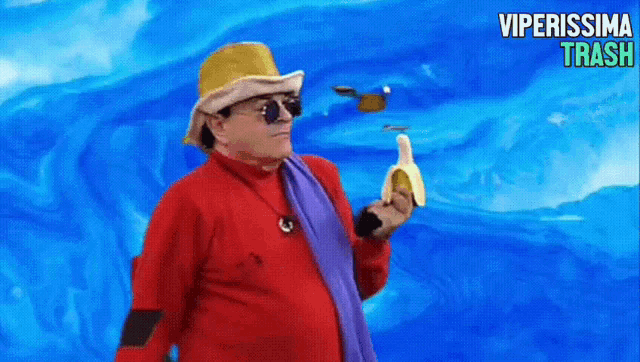 a man in a red shirt is holding a banana in front of a blue background that says viperissima