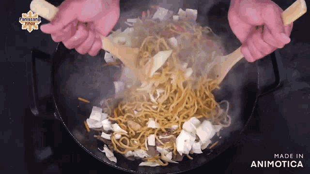 a person is stirring noodles with wooden spoons in a pan that says made in animotica on the bottom