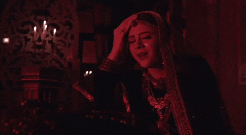 a woman in a dark room with candles on the wall