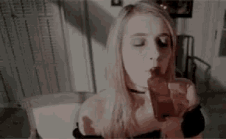 a woman is sitting in a chair eating a piece of meat .