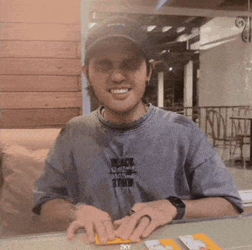 a man wearing a hat that says just do it smiles