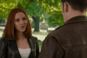 a man and a woman are standing next to each other and looking at each other