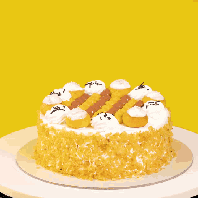 a close up of a yellow cake with white frosting on a yellow background