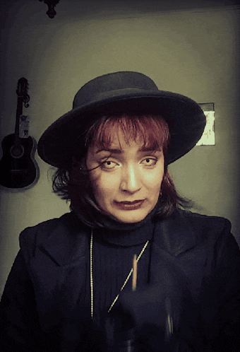 a woman wearing a black hat and a black turtleneck