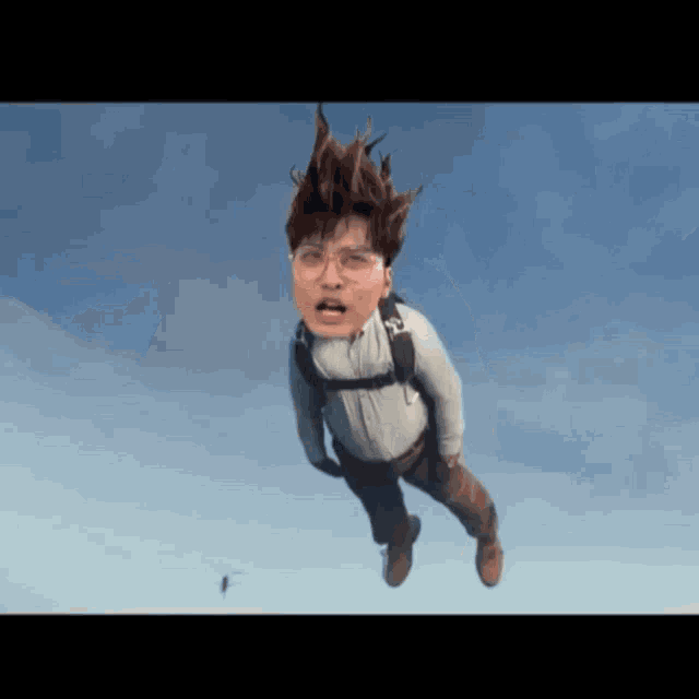 a man with glasses is flying through the air with a backpack on his back