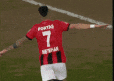 a soccer player wearing a jersey that says otoka jumps in the air