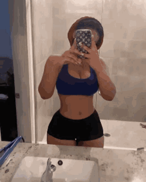a woman taking a selfie in front of a mirror