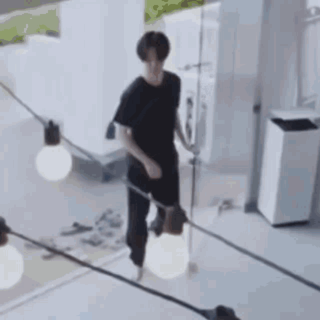 a man in a black shirt is walking on a tightrope .
