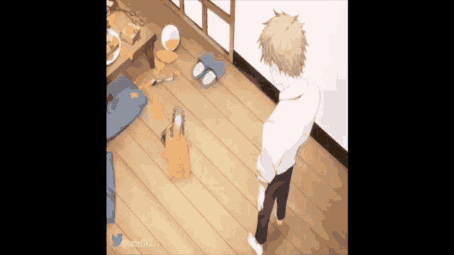 a man is standing on a wooden floor in a room with a cat .