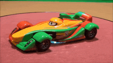 a toy race car is sitting on top of a red table .