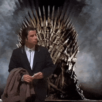 a man in a suit sits in front of a throne