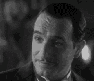 a man in a tuxedo and bow tie is smiling