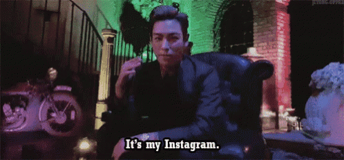 a man in a suit is sitting in a chair and says " it 's my instagram "