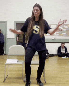 a woman in a blue shirt with the letter s on the front