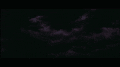 a dark purple sky with a few white clouds