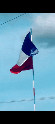a blue white and red flag is waving in the wind .