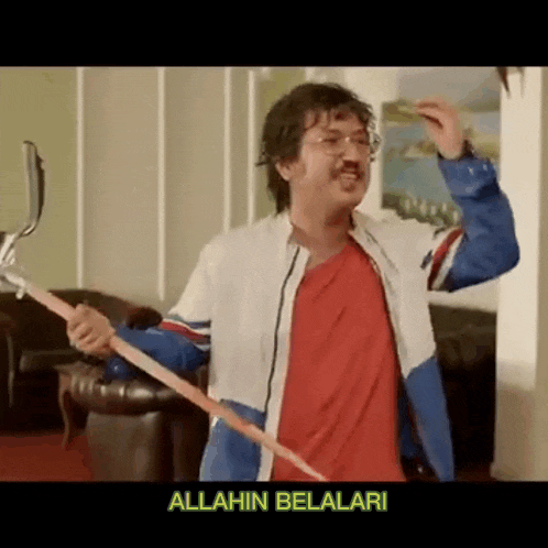 a man in a red shirt and blue jacket is holding a stick with the words allahin belalari on the bottom