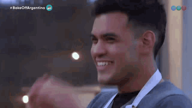 a man is smiling in front of a sign that says #bake offargentina
