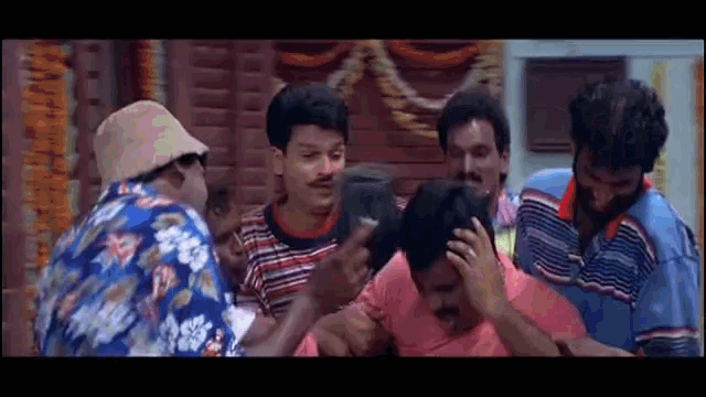 a group of men are standing around a man 's head and talking to him .