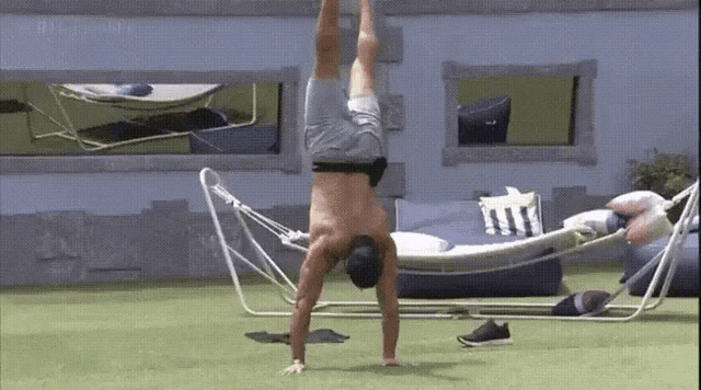 a man is doing a handstand on the grass