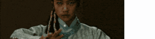 a woman in a traditional costume is holding a sword .