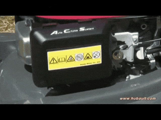 a close up of a lawn mower engine with a warning label on it