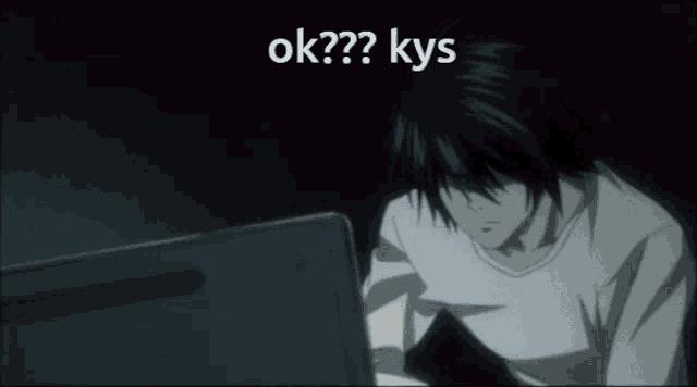 a man sitting in front of a laptop with the words ok?? kys written on the screen
