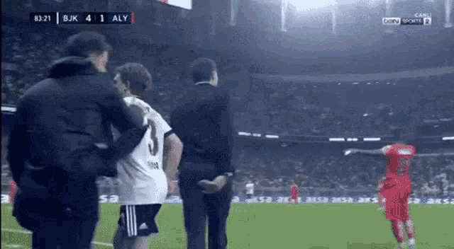 a soccer player with the number 3 on his shirt is being helped off the field