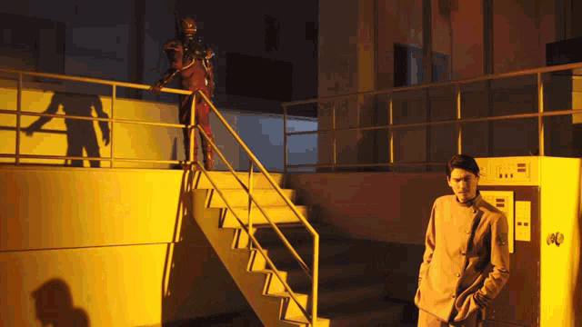 a man in a suit is standing on a set of stairs with a robot behind him