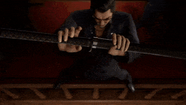 a man in a suit is holding a sword in front of a group of men