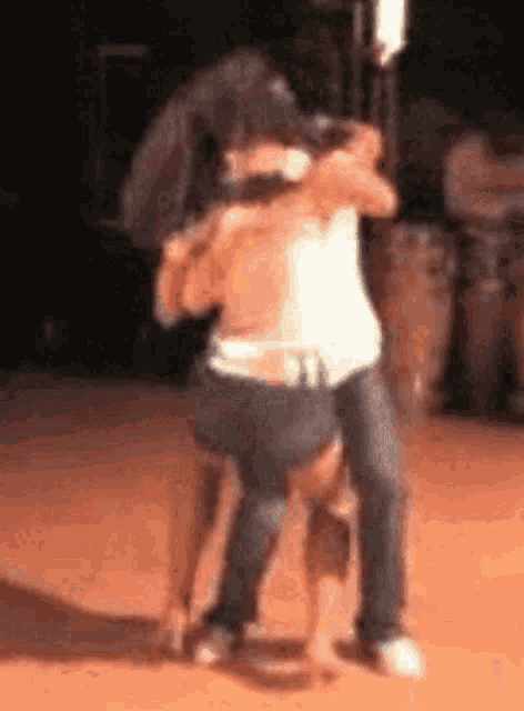 a blurry picture of two people hugging each other on a dance floor