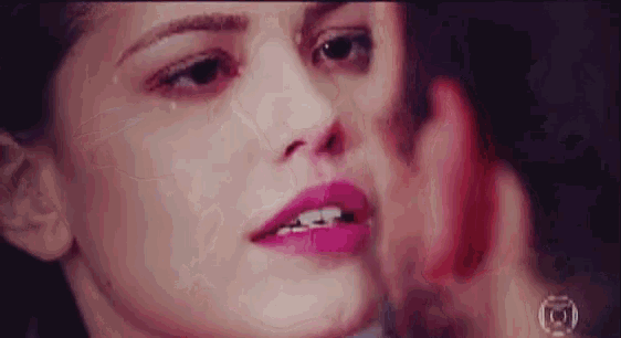 a close up of a woman 's face with a tear running down her eye .