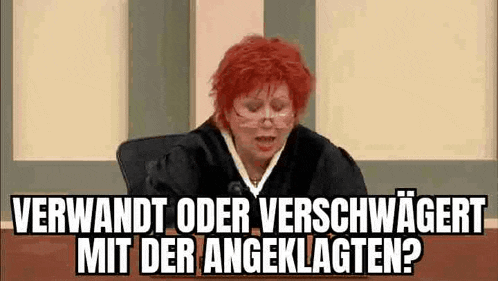 a woman with red hair is sitting in front of a judge in a courtroom and talking .