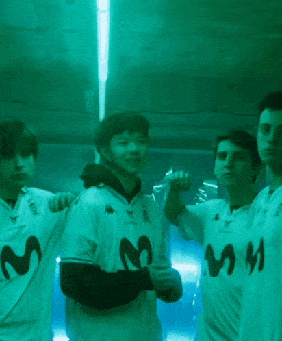 a group of young men wearing white shirts with the letter m on them are posing for a picture