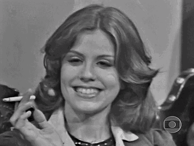 a black and white photo of a woman smoking a cigarette .