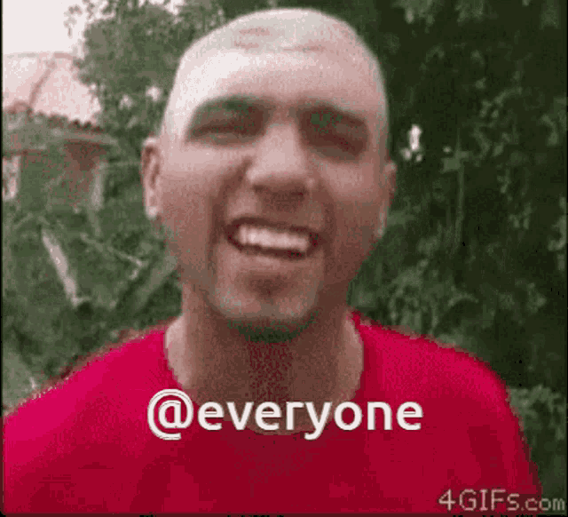 a man in a red shirt is smiling with the words @everyone above him