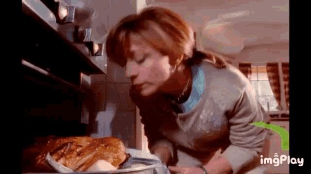 a woman is taking a loaf of bread out of the oven .