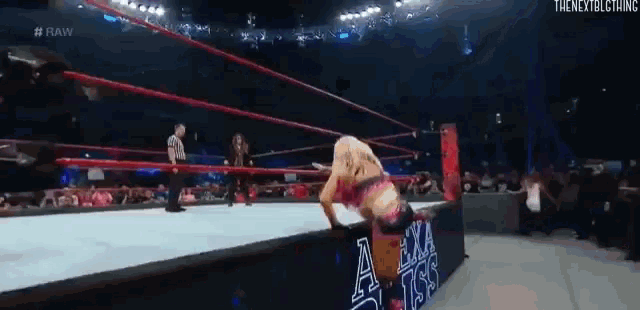 a woman is wrestling in a wrestling ring with a sign that says a.m.a.a.a.a.