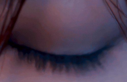 a close up of a woman 's brown eye with long eyelashes