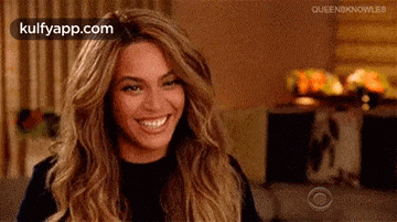 a woman with long hair is smiling in a room .
