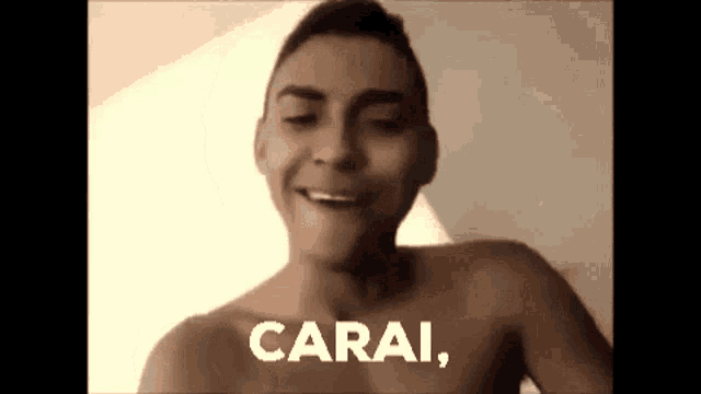 a shirtless man is smiling with the words carai written on his chest .