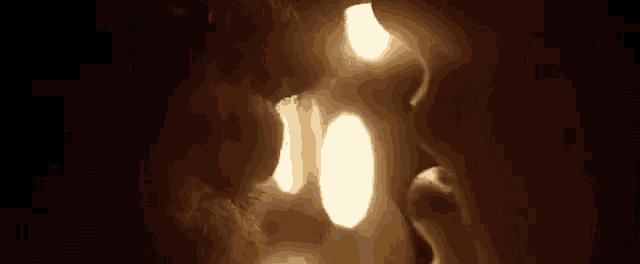 a close up of a man and woman kissing in front of a light .