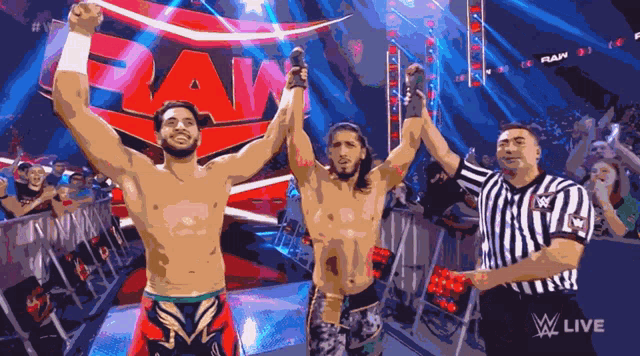 three wrestlers are standing in front of a raw logo