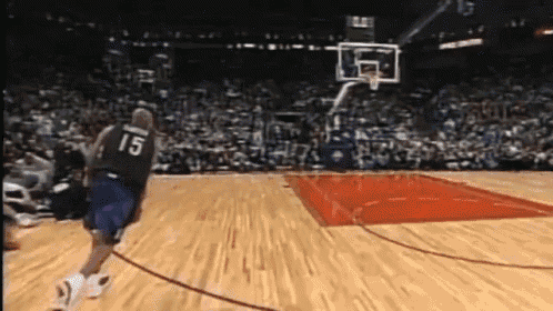 a basketball player with the number 15 on his jersey runs towards the basket