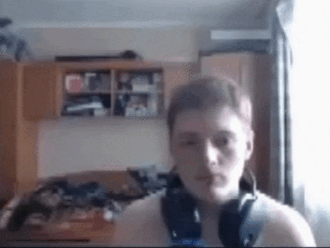 a young man wearing headphones is looking at the camera .